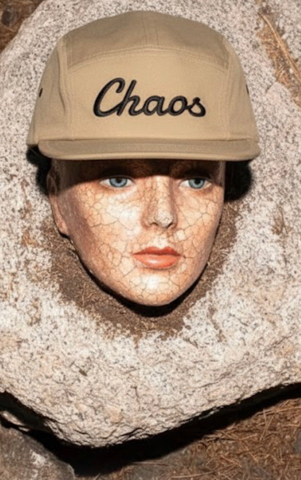 Person wearing a cap with 'Chaos' text on a textured surface